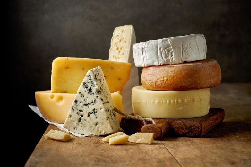 vari tipi di formaggio su tavola di legno rustica